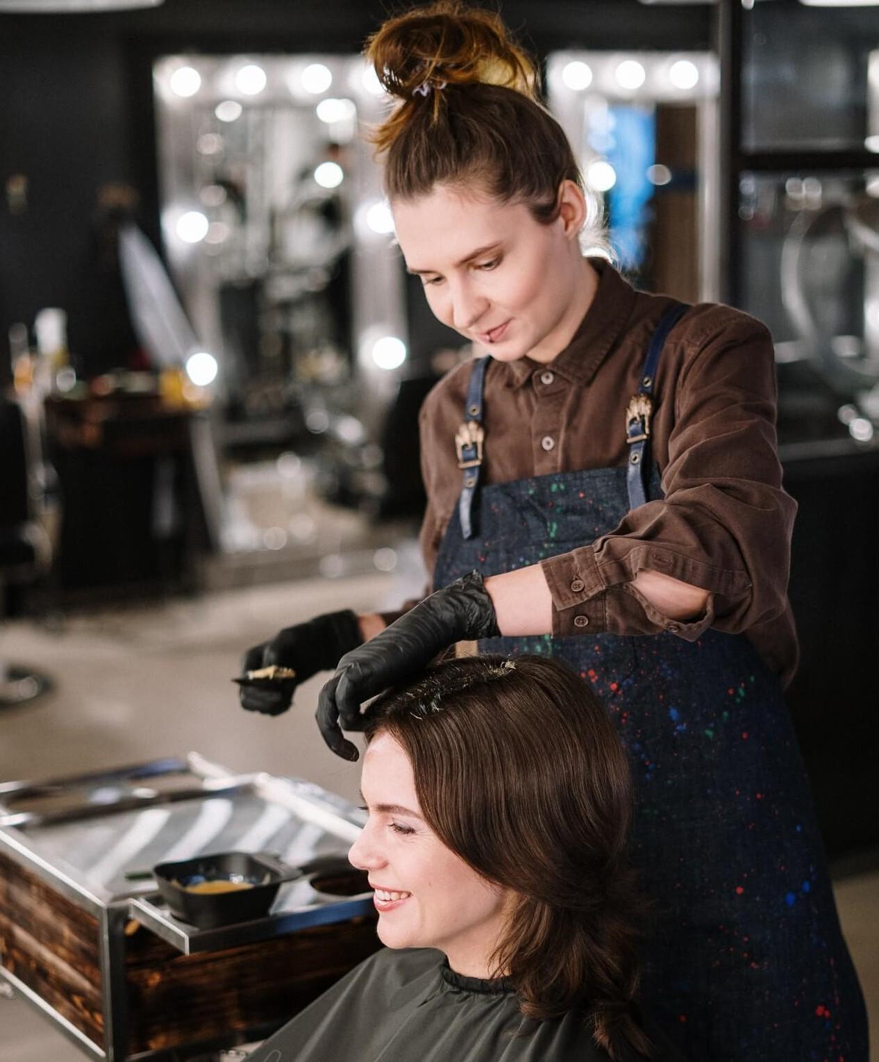 Frizerka ureja ženski frizuro.