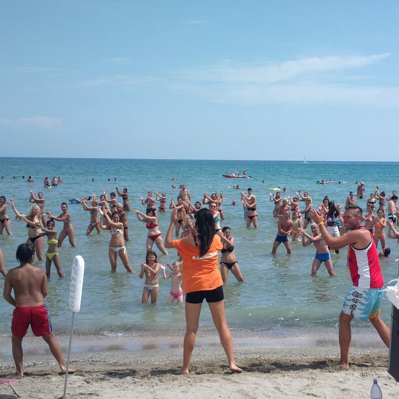 Turistični animatorji na plaži izvajajo telovadbo