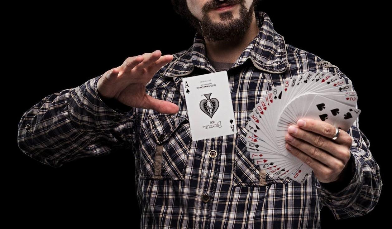 Čarovnik izvaja trik s kartami.