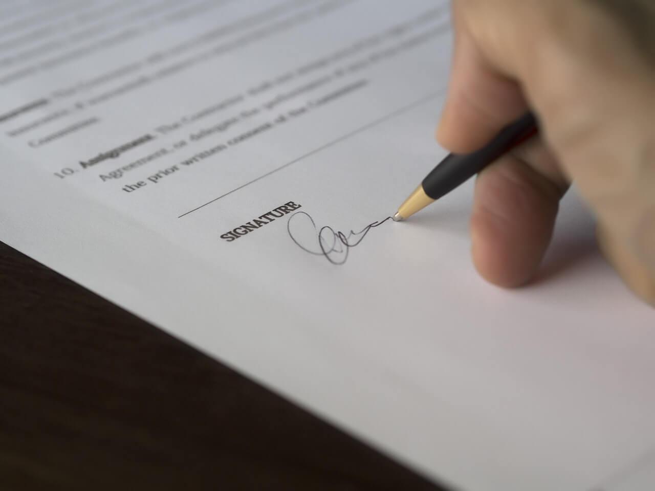 Dokument in roka, ki ga podpisuje.